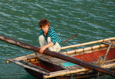 Vietnamese boy with reddish hair in a rowboat, Halong Bay