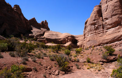 Delicate Arch behind pyramid-shaped point at upper left