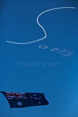 Australian flag over Sydney Harbour with Sorry skywriting