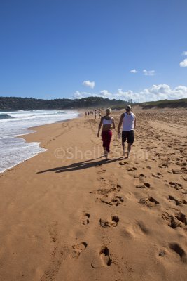 Couple walking on beach at Palm Beach, Sydney 