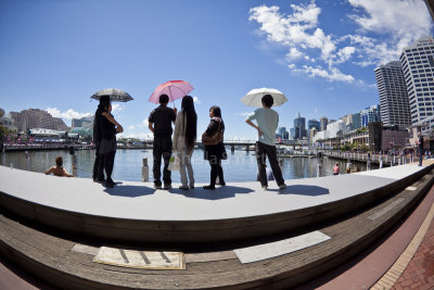 Tourists with umbrellas at Darling Harbour 