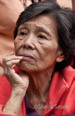 Pensive Asian lady at festival