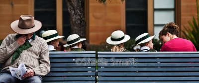School girls in hats on bench 