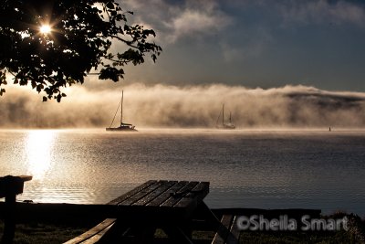 Two yachts in rolling dawn mist