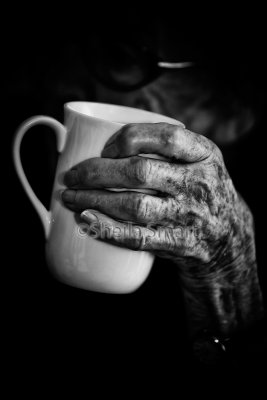 Ageing hand holding mug