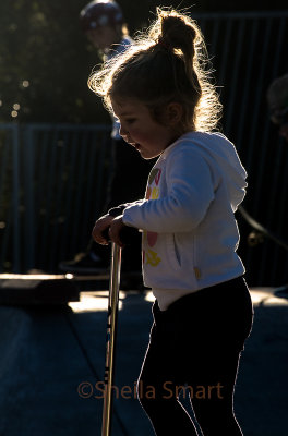Backlit little girl at skate park 