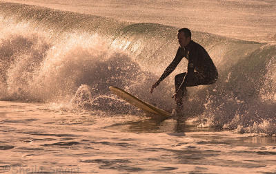 Surfer in late afternoon  winter sun