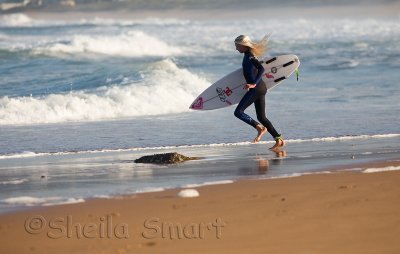 Girl surfer entering water