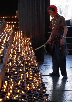 Man lighting up yak butter candles