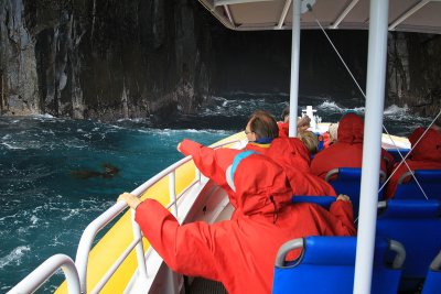 Entering a cave, Southern Coast, Tasmania. on board adventure cruise.