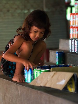 4th Place-Cute crouching Cambodian child counting cola cans-by Najinsky