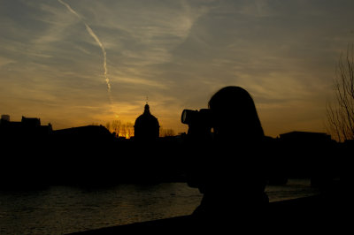 Sam silhouetted at sunset by the Seine