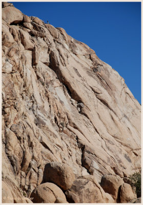 Two tiny rock climbers at the top