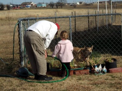 Katie and Tawney helping Pops to water the plants