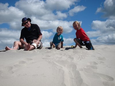 Pop, Charli and Zach on top of a sand dune