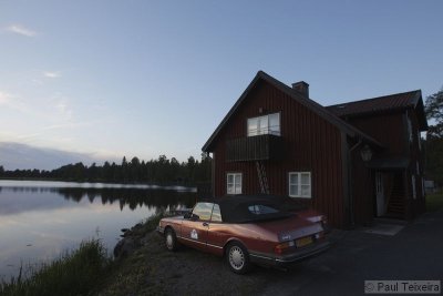 Two Saab 900 Cabriolet stand at the setting of sun near a lake in Sweden