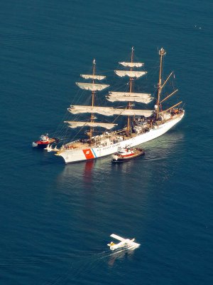 USGC Barque Eagle, escorted by SeaSpan tugs (note white aprons), leaving Tall Ships 2008 Victoria B.C. Horizon Air Beaver arriving from Vancouver B.C.