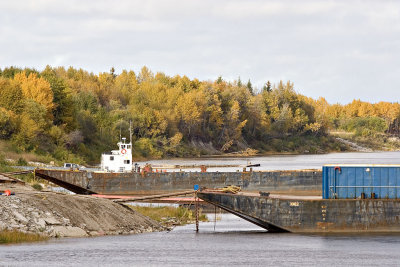 Barges docked in front of fall foliage