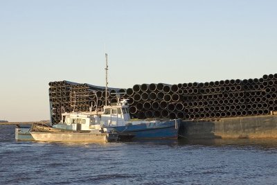 Tugs and barge loaded with pipe