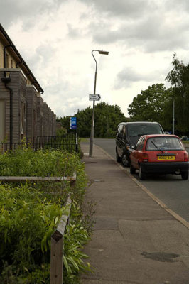 Cars parked on the main road outside the last new build