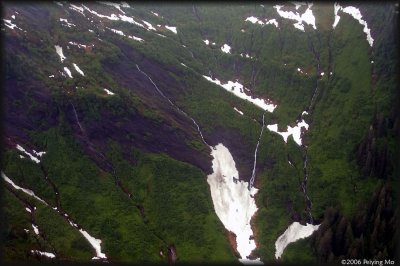The mountain slope is laced with waterfalls