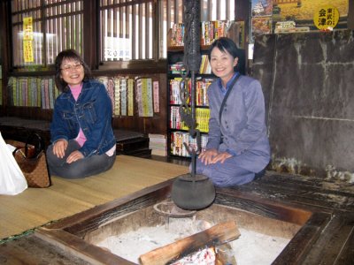 Japanese travelers staying warm by the open fire.