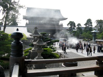 Smoke from a temple incense burner fills the air.
