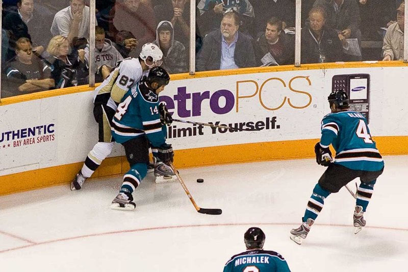 Sidney Crosby and Jonathan Cheechoo fight for the puck