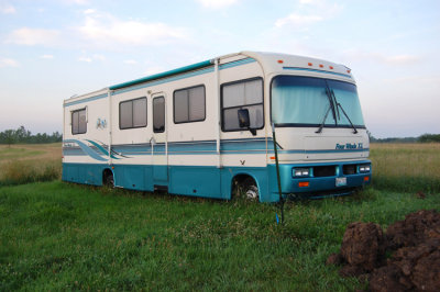 This belongs to a friend of mine, the same guy who owns the dump truck. (One of two he owns) He bought this for his wife because she said she wanted one to take trips with. So, they did ... once. Since then it's been parked in the field behind the farm house, like this, for a few years now.