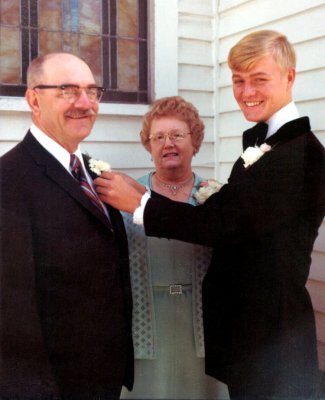 Here we see, David Arthur Robinson pinning a corsage onto his father's lapel, on his wedding day. Shown above, left to right we see, Harold Everette Robinson, his wife, Lucille Alena [Mattson] Robinson, and their son, David Arthur Robinson, on the day of his wedding to, Lois Marie St. Clair.  