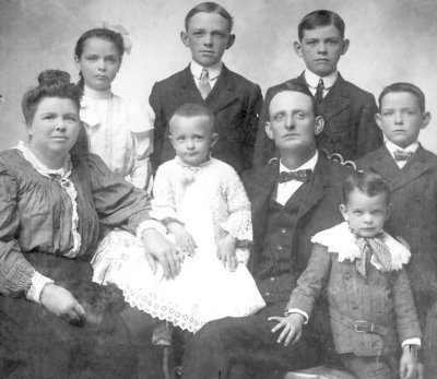 1905: The Jennings family. Dad, the baby of the group looking very self-conscious in his white gown.