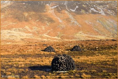 IRELAND - CO.GALWAY - TURF STACKED BENEATH MAUMTURK MOUNTAINS