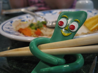 Gumby rests from the hard work of using chopsticks that are bigger than he is