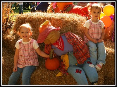 Noelle and Kylie sit with the scarecrow