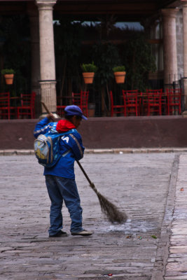 Sweeping the square with a broom made of twigs.