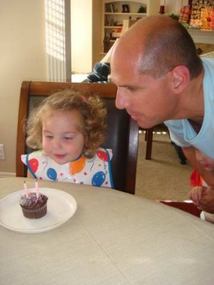 daddy helps her blow out the candles