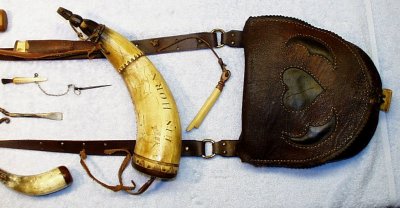 Close Up View Of Schrimshawed Horn And Hunting Bag With Tools