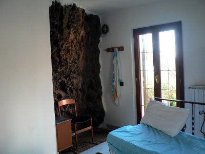 Bedroom of our affita camere.  Notice the rock wall!