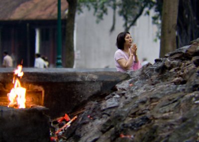 Praying at the statue of revered Ly Thai To, founder of Ly dynasty (11th century)