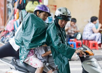 One  motorscooter, one rain poncho -- enough for a family of four