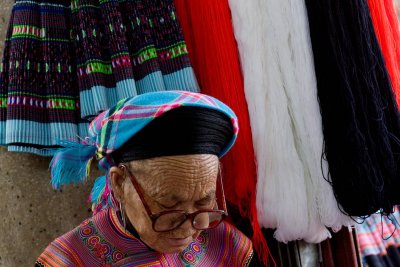 Older woman making traditional clothing at a craft shop in Sapa