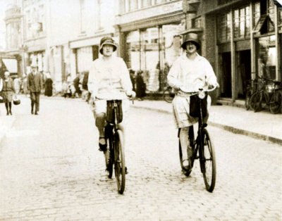 Marie and Truus on their ladies bikes through the streets of Enschede
