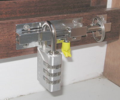 Combo lock, behind the slide bolt, preventing opening of latch.