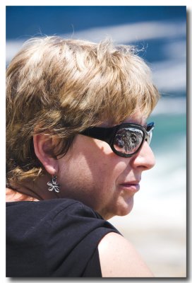....Liz's glasses reflect the day with the rock ledge reflected.