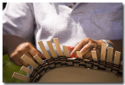.....a woman weaves baskets.