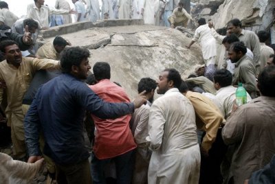 PAKISTANI RESCUE WORKERS REMOVE DEBRIS AT THE SCENE WHERE A TWO STOREY BUILDING COLLAPSED IN RAWALPINDI.
