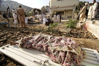 A body of a Kashmiri earthquake victim lies next to a collapsed building of a school in Muzaffarabad.jpg