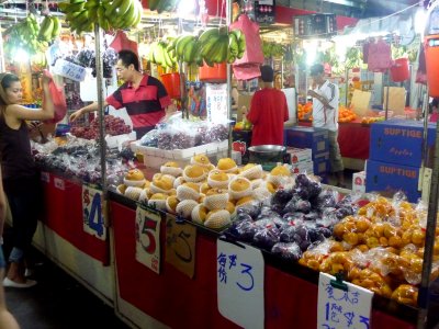 Fruit vendor and a customer at the night market.
