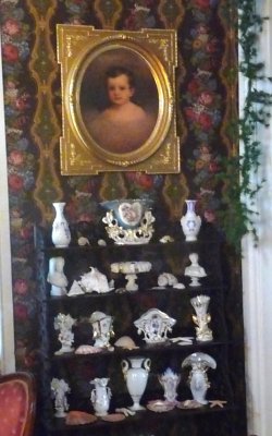 Bric-a-brac that Adelicia collected are period pieces. A copy of a baby portrait of Claude, one of her sons who survived her.