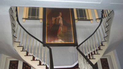 A portrait of a young Queen Victoria hangs over the grand staircase off of the Grand Salon.